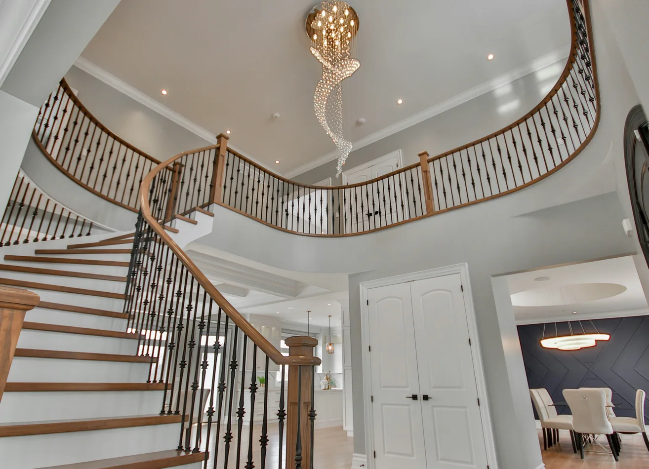 Hall à double hauteur : escalier hélicoïdal en bois et suspension en cascade