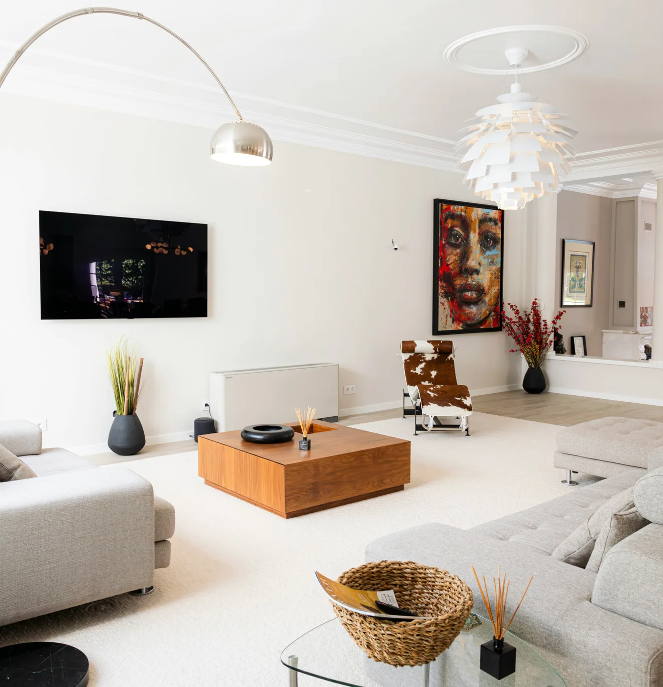 Séjour contemporain éclairé par une lampe arc et une suspension à pétales