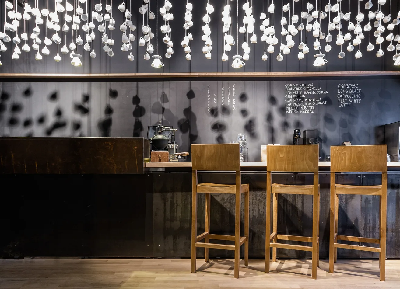 Comptoir de bar en bois sombre éclairé par une pluie de petites suspensions