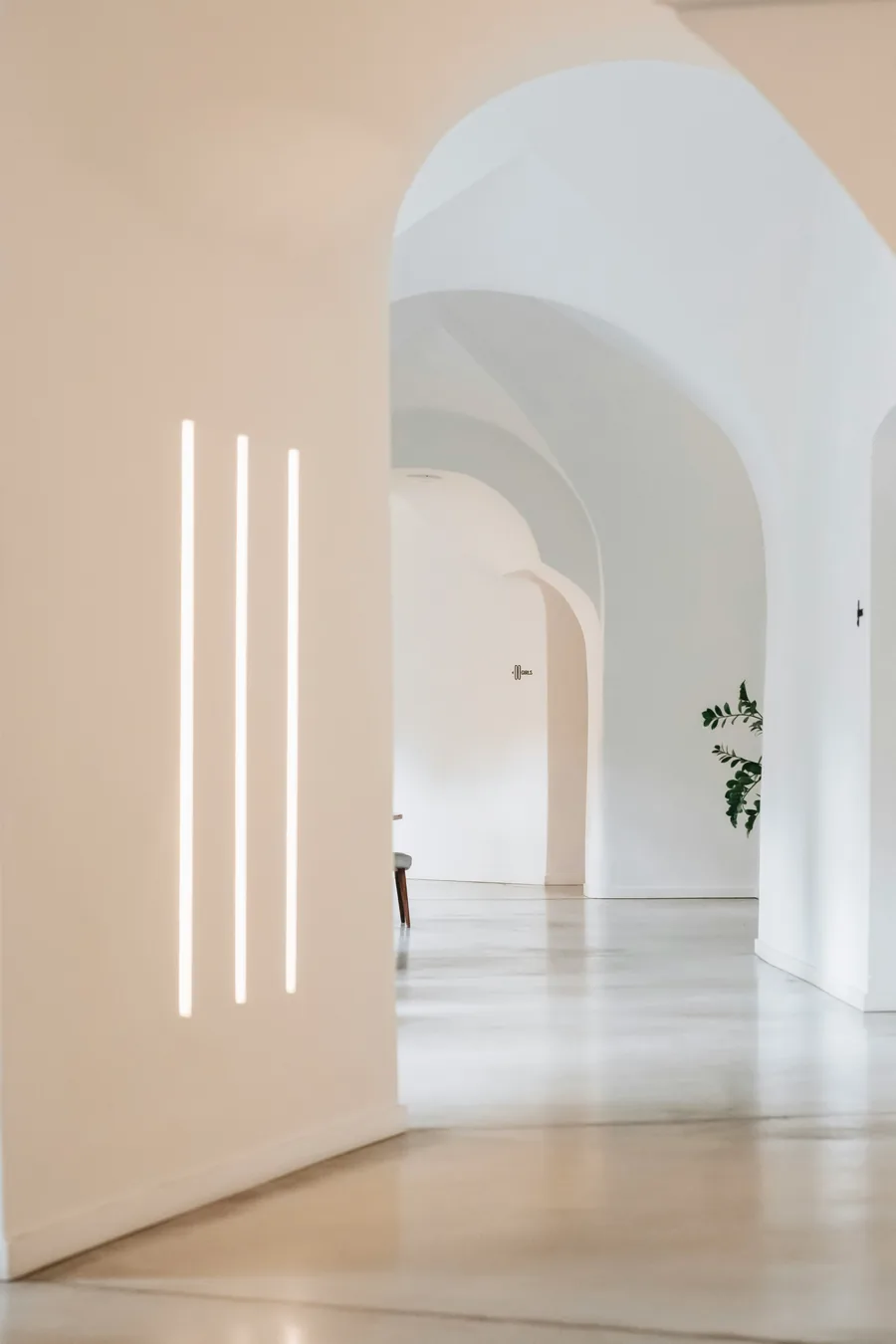 Couloir voûté éclairé par trois tubes lumineux verticaux